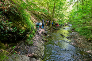 An der engsten Stelle in der Ehrbachklamm hangeln sich Wanderer an Drahtseilen entlang An der engsten Stelle in der Ehrbachklamm hangeln sich Wanderer an Drahtseilen entlang